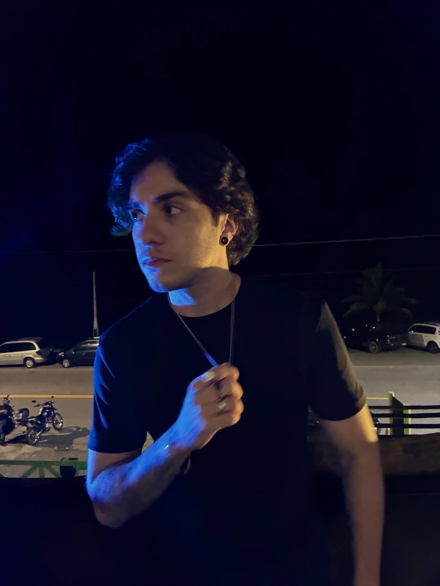 Gabriel under blue light on a terrace at night